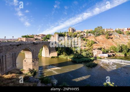 Vue sur le pont de San Martin traversant le Tage pour entrer dans la vieille ville de Tolède sur la colline où vous voyez la vieille cathédrale Banque D'Images