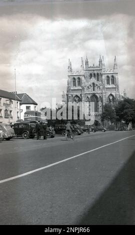 Circa 1950s, historique, York, Angleterre, Royaume-Uni, montrant la grande cathédrale gothique, connue sous le nom de York Minster. Voitures de l'époque garées et un bus à impériale allant à Leeds, avec une annonce pour Barnsley Brewery. Chauffeur de bus et chef d'orchestre féminin à l'extérieur discutant avec le superviseur. Banque D'Images