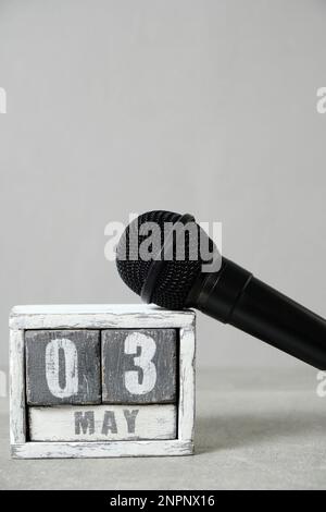 3 mai, calendrier et microphone noir fond gris. Concept pour la Journée mondiale de la liberté de la presse Banque D'Images