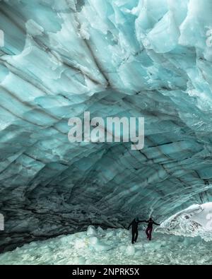 Couple tenant les mains, en randonnée dans une incroyable grotte de glace dans le territoire du Yukon, Canada. Hiver dans le territoire du Yukon. Banque D'Images