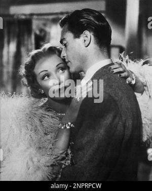 1950 : l'actrice MARLENE DIETRICH avec RICHARD TODD en SCÈNE FRID ( Paura en palcoscenico ) Par Alfred Hitchcock - CINÉMA - FILM - plumes - boa di piume di struzzo - marabù - TILLER - GIALLO - unghie - ongles - abbraccio - embrase - amanti - amants - innamorati - assassina - killer - bracelet - braccialetto - diamands - diamante - diamanti - bijoux - bijoux - gioiello - gioielli - cheveux blond - bionda - capelli biondi - profilo - profil - --- Archivio GBB Banque D'Images