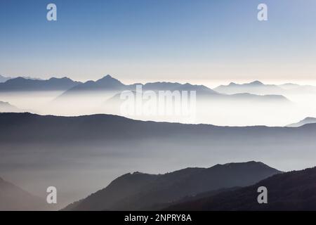 Paysage de montagne brumeux dans l'Himalaya, au Népal. Belle vallée de montagne remplie de brume tôt le matin. Une chaîne de montagnes très brumeuse surmonte le blanc Banque D'Images