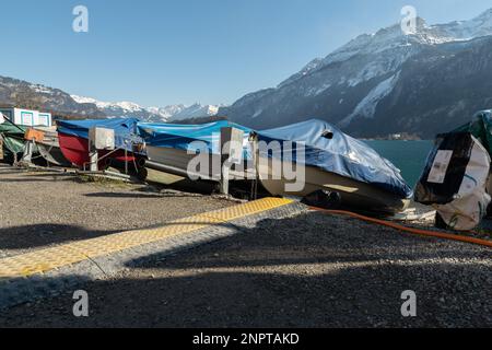 Brienz, Suisse, 10 février 2023 de petits bateaux sont couverts et entreposés sur la côte du lac de Brienz Banque D'Images