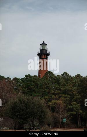 Le phare de Old Brick surplombe la forêt et le quai avec plage Banque D'Images