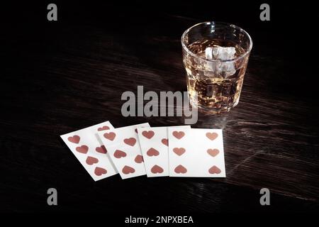 Cartes à jouer et whisky sur table en bois Banque D'Images