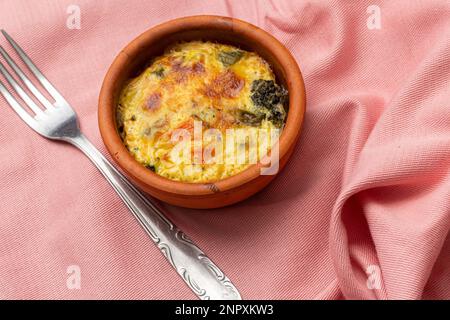 Délicieuse collation saine ou repas : mini frittata dans un petit plat, mangée avec une fourchette. Banque D'Images