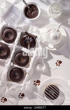Beignets au chocolat glacé et tasse de cappuccino sur fond de pierre.Vue de dessus.Composition de la pose à plat Banque D'Images