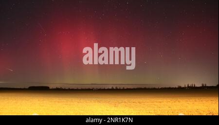 Rathenow, Allemagne. 26th févr. 2023. Auroras brillent sur le Brandebourg lors de ce tir de nuit avec une longue exposition. Une forte éruption au soleil a conduit à des effets lumineux rouges et verts dans l'atmosphère, qui ne peut autrement être vu que dans le nord de la Scandinavie ou sur l'Islande. Le spectacle naturel était particulièrement bien visible dans les endroits sombres de Brandebourg et de Saxe-Anhalt. Credit: Cevin Dettlaff/dpa/Alay Live News Banque D'Images