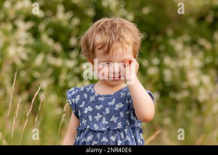 L'enfant frotte ses yeux fatigués Banque D'Images