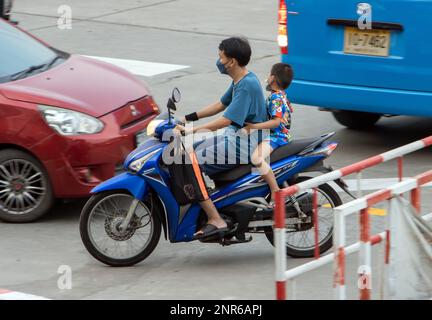 SAMUT PRAKAN, THAÏLANDE, FÉVRIER 03 2023, Un homme roule avec un garçon sur une moto. Banque D'Images