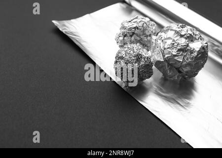 Boules de papier aluminium froissé sur fond sombre, gros plan Banque D'Images