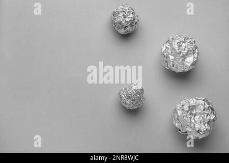 Boules de papier aluminium froissé sur fond gris Banque D'Images