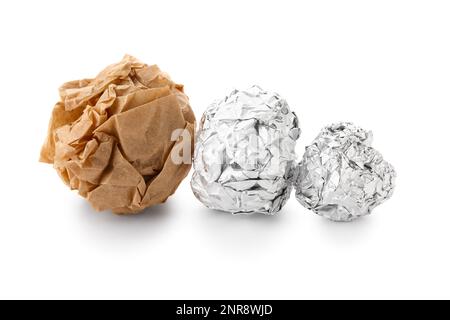 Des boules de papier aluminium froissé et de papier de cuisson sur fond blanc Banque D'Images