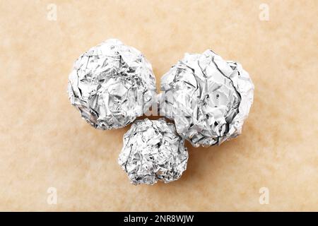 Boules de papier aluminium froissé sur fond de couleur Banque D'Images