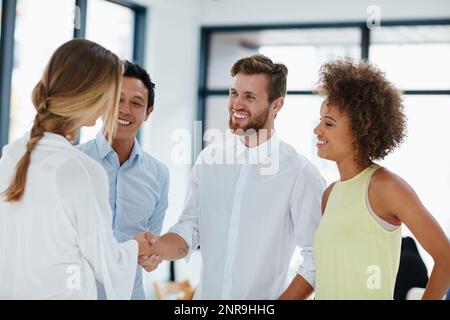 Étaient tous fiers de votre succès. un groupe de gens d'affaires félicitant leur collègue pour une promotion en lui serrant la main. Banque D'Images