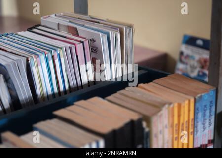 L'arrangement des livres soigneusement alignés sur les étagères de la bibliothèque scolaire, dans le village d'Air Belo pendant la journée Banque D'Images