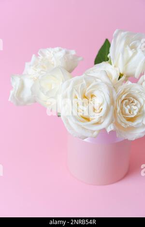 Bouquet de roses blanches sur fond rose dans une boîte. Concept de fête des mères, de Saint-Valentin, de fête d'anniversaire. Carte de vœux. Copier l'espace pour le texte. Banque D'Images