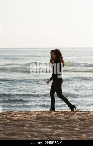 Jeune femme marche sur la plage Banque D'Images