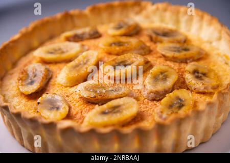 Gâteau éponge au yaourt à la banane avec des morceaux de fruits frais et de chocolat sur le dessus Banque D'Images