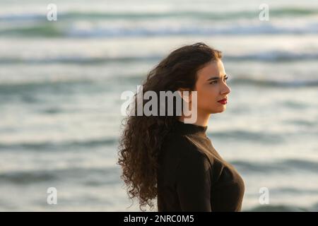 Femme qui regarde loin sur la plage Banque D'Images