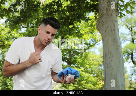 Homme avec le bloc froid souffrant de coup de chaleur à l'extérieur Banque D'Images