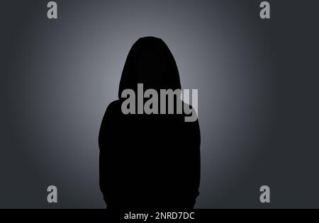 Silhouette de femme anonyme sur fond sombre Banque D'Images