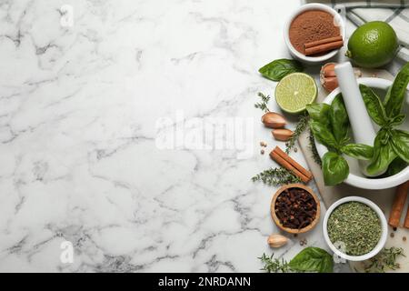 Différentes épices naturelles et herbes sur table en marbre blanc, plat. Espace pour le texte Banque D'Images