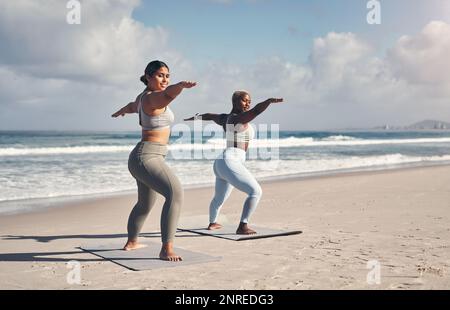 Le yoga est un art que vous devez pratiquer quotidiennement. deux jeunes femmes pratiquant le yoga sur la plage. Banque D'Images