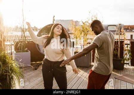 Homme et femme insouciants dansant ensemble sur la terrasse Banque D'Images