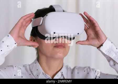 Gros plan de femme d'affaires interagissant avec des lunettes VR. Banque D'Images