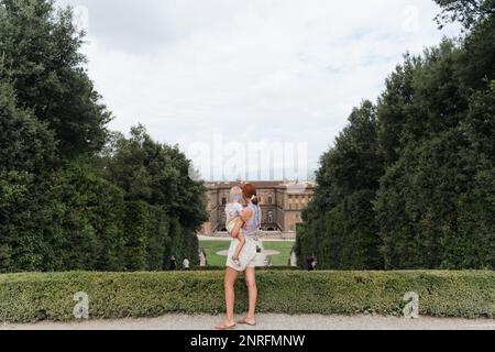 Femme avec un tout-petit dans ses bras dans le point de vue des jardins de Boboli Banque D'Images