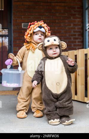 Les enfants en bas âge portent des costumes sur le porche avant Banque D'Images