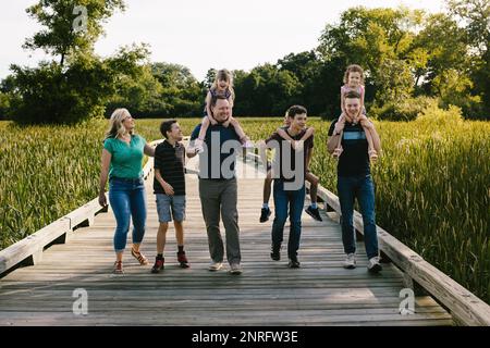 Une grande famille se balade ensemble à travers le terrain en plein air heureux Banque D'Images