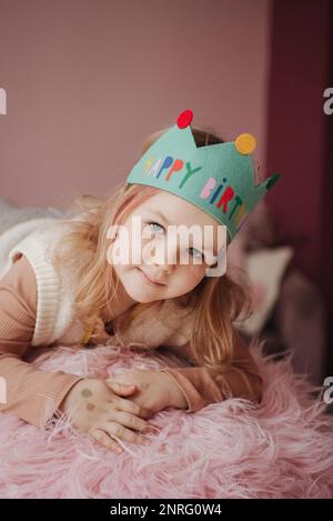 fille dans une couronne verte sur un fond rose Banque D'Images