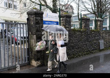 Les parents d'élèves et d'enfants viennent déposer des fleurs en hommage à l'enseignant assassiné devant le collège privé Lycée de Saint Thomas d'Aquin à Saint Jean de Luz. 23 février 2023. Une enseignante espagnole au lycée Saint-Thomas-d'Aquin de Saint-Jean-de-Luz, Pyrénées-Atlantiques, est décédée après avoir été poignardée en classe par un étudiant de sa classe mercredi 22 février. L'étudiant de 16 ans du secondaire accusé de l'assassinat a déclaré en garde à vue avoir entendu des voix lui demandant de tuer son professeur, l'expert psychiatre qui l'a examiné le considérait responsable Banque D'Images