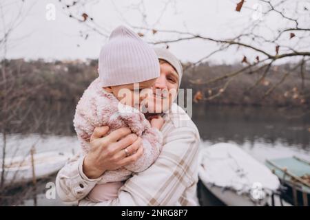 Papa secoue sa fille de deux ans dans les bras et sourit Banque D'Images