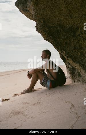 L'homme sur la plage. Un touriste avec un sac à dos marche le long du Banque D'Images