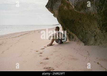 L'homme sur la plage. Un touriste avec un sac à dos marche le long du Banque D'Images