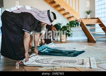 Renforcer ma relation spirituelle. un groupe d'hommes musulmans plaçant leurs tapis de prière en préparation. Banque D'Images