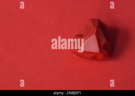 Fond de Saint-Valentin, un délicieux chocolat rouge sur fond rouge Banque D'Images