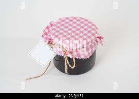 Pot de confiture de fraises maison avec étiquette vide isolée sur fond blanc Banque D'Images