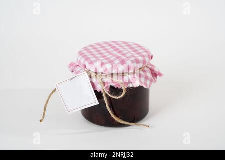 Pot de confiture de fraises maison avec étiquette vide isolée sur fond blanc Banque D'Images