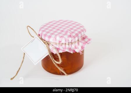 Pot de confiture d'abricot maison avec étiquette vide isolée sur fond blanc Banque D'Images