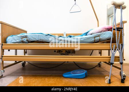 vue latérale du lit d'hôpital électrique réglable et des béquilles à la maison Banque D'Images