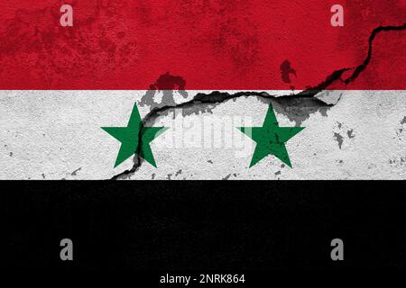 Tremblements de terre en Syrie, drapeau de la Syrie sur un mur avec des fissures d'un tremblement de terre Banque D'Images