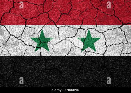 Tremblements de terre en Syrie, drapeau de la Syrie sur un mur avec des fissures d'un tremblement de terre Banque D'Images