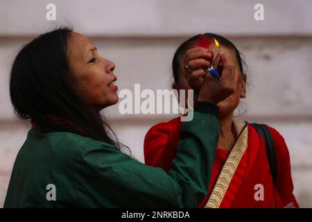 Katmandou, Népal. 27th févr. 2023. Sur 27 février 2023 à Katmandou, Népal. Les femmes dévotées illuminent la lampe en coton après avoir éréorganisé le poteau de cérémonie marquant le début du festival « Holi ». (Photo de Abhishek Maharajan/Sipa USA) crédit: SIPA USA/Alay Live News Banque D'Images