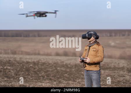 Un homme contrôle un drone dans des lunettes spéciales FPV Banque D'Images