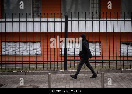 Kiev, Ukraine. 24th févr. 2023. Kiev, Ukraine - 24 février 2023: Un homme marche à côté de sacs de sable fenêtre. La vie quotidienne à Kiev à l'occasion du 1 ans de la guerre totale de la Russie. (Photo de Kish Kim/Sipa USA) *** Corée out *** Credit: SIPA USA/Alay Live News Banque D'Images