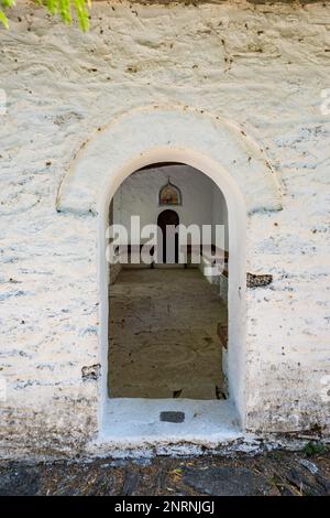 Vue latérale encadrée par une fenêtre en pierre voûtée. Eglise Saint George, village Mikros Pinos, île de Thasos, Grèce. Banque D'Images